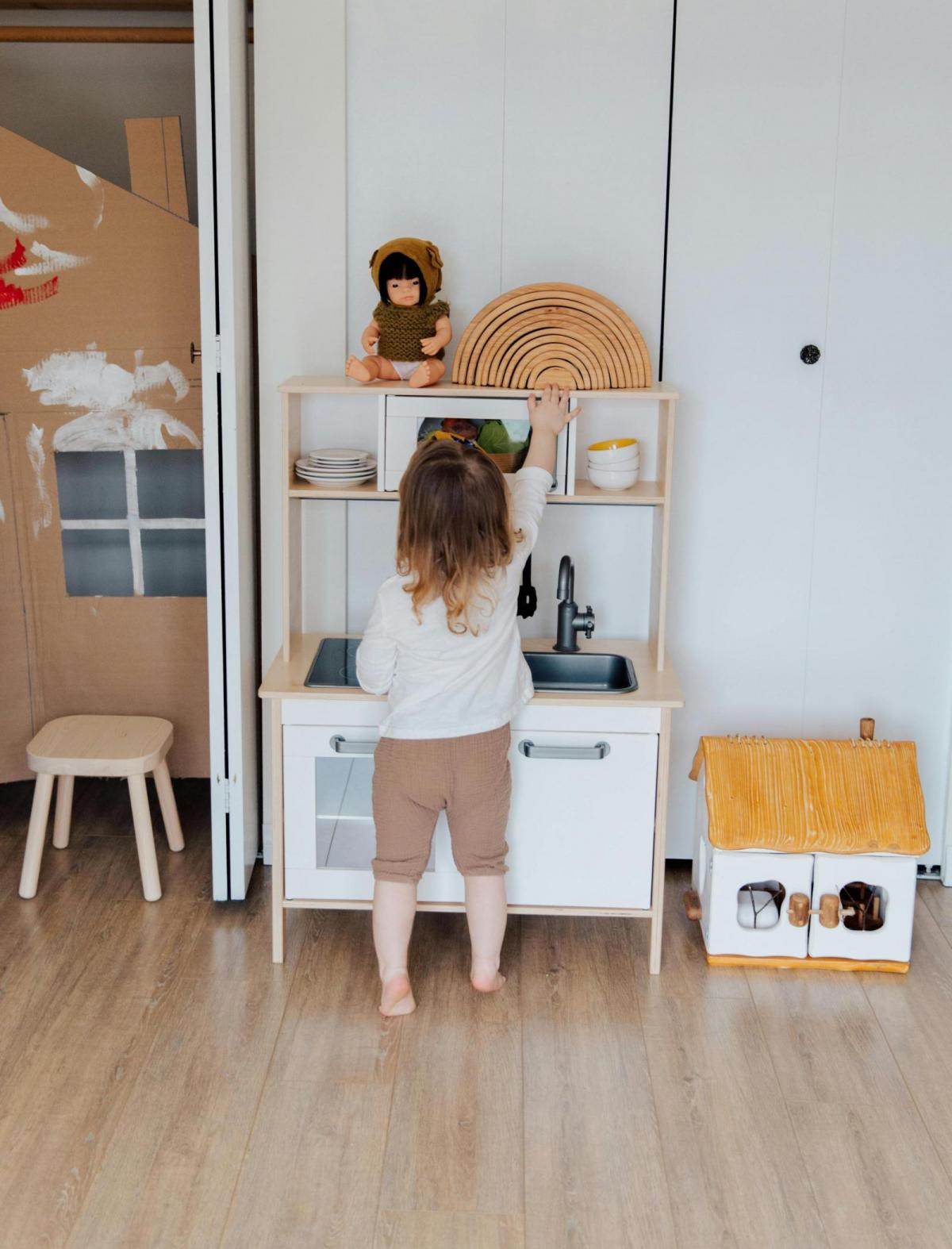 Kleines Kind spielt in einer Holzküche